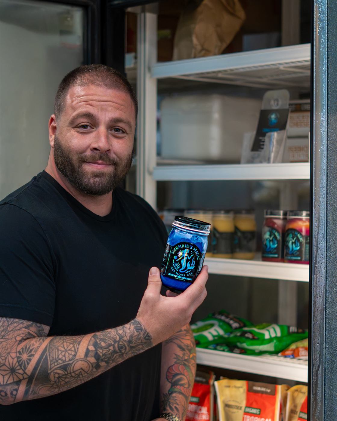 Alan holding a jar of Mermaids Magic sea moss gel in a store