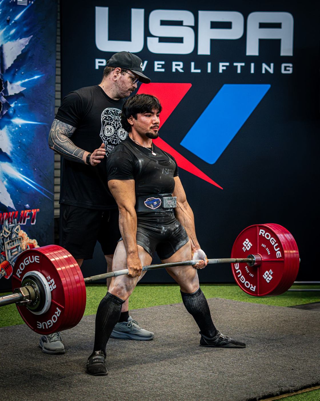 A lifter locking out a deadlift