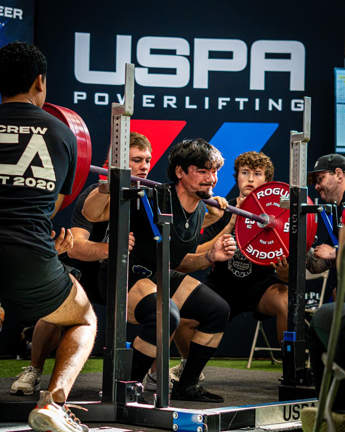 A squat with spotters on both sides